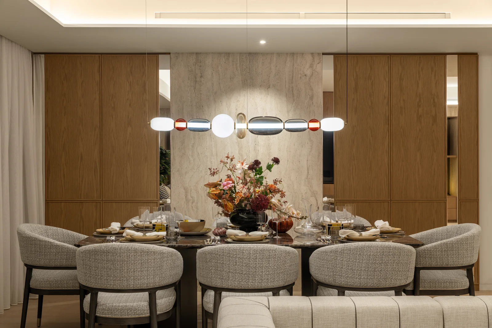Natural-marble dining table set for eight under a glass chandelier